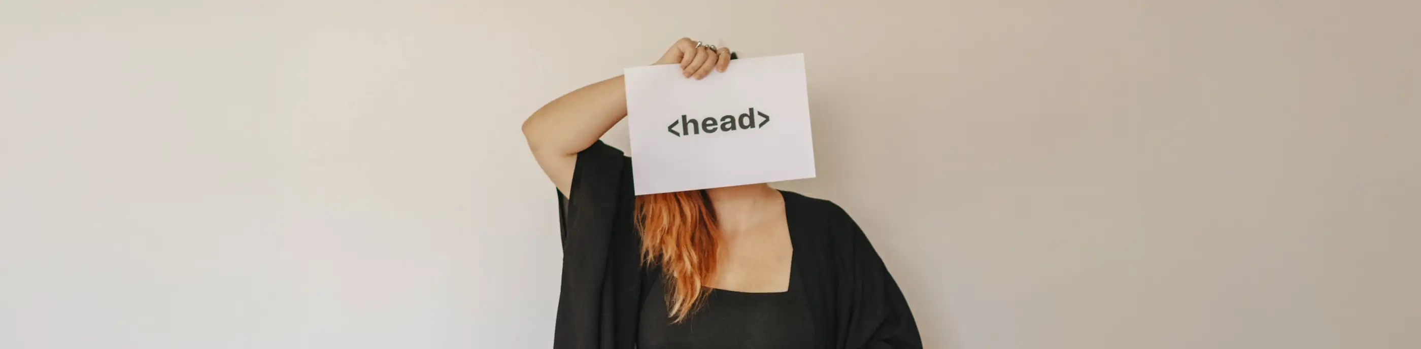 Janine, fondatrice de FOC Studio, tenant une feuille imprimée d'une balise head devant son visage